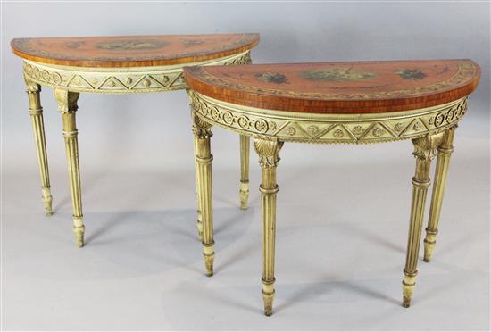 A near pair of Edwardian painted satinwood and giltwood demi-lune console tables, W.3ft 3in. D.1ft 5in. H.2ft 6in.